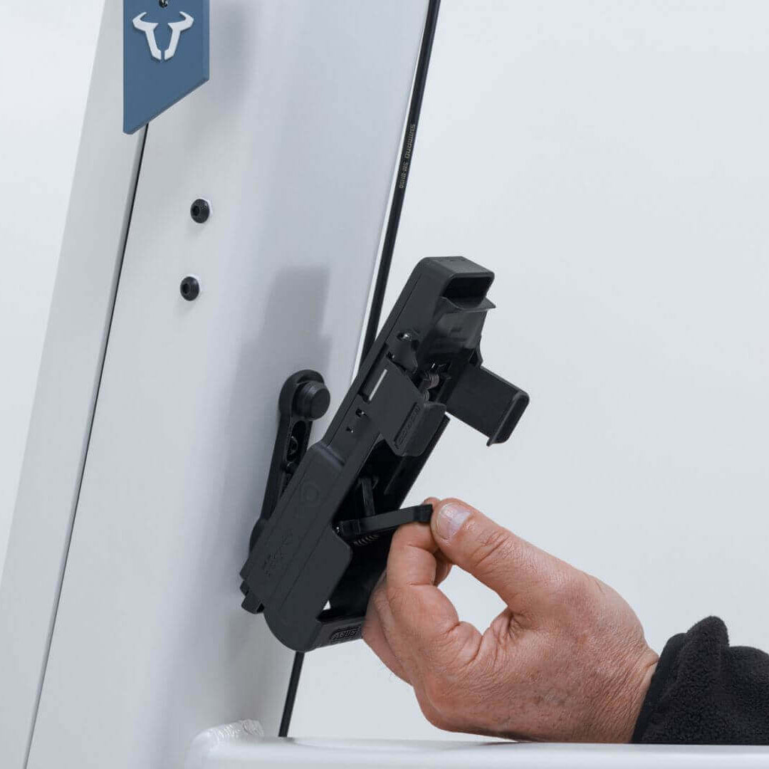 ABUS Bordo 6000K Faltschloss mounted on a bike frame with hand inserting a key.