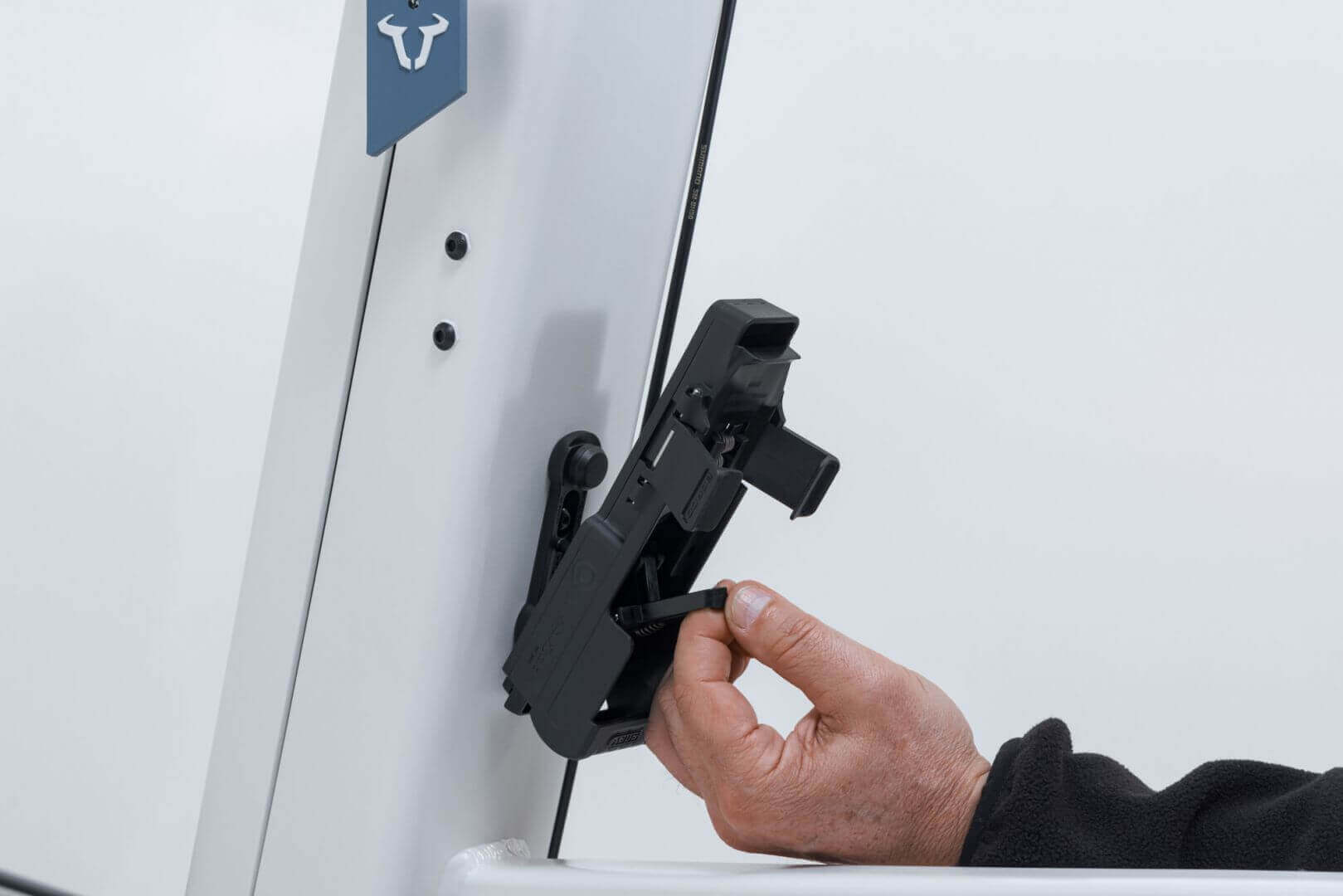 ABUS Bordo 6000K Faltschloss mounted on a bike frame with hand inserting a key.