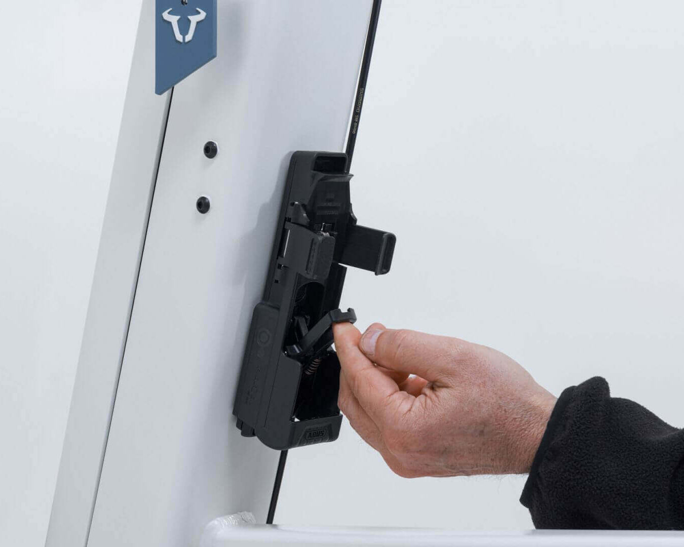 Hand attaching ABUS Bordo 6000K Faltschloss to Fidlock mount on a bike frame.