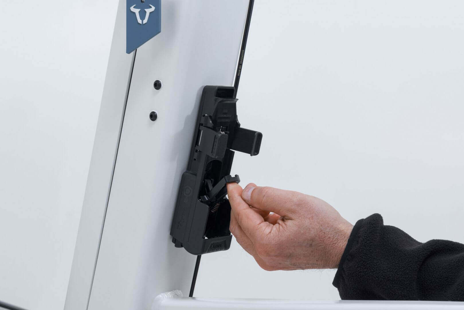 Hand attaching ABUS Bordo 6000K Faltschloss to Fidlock mount on a bike frame.